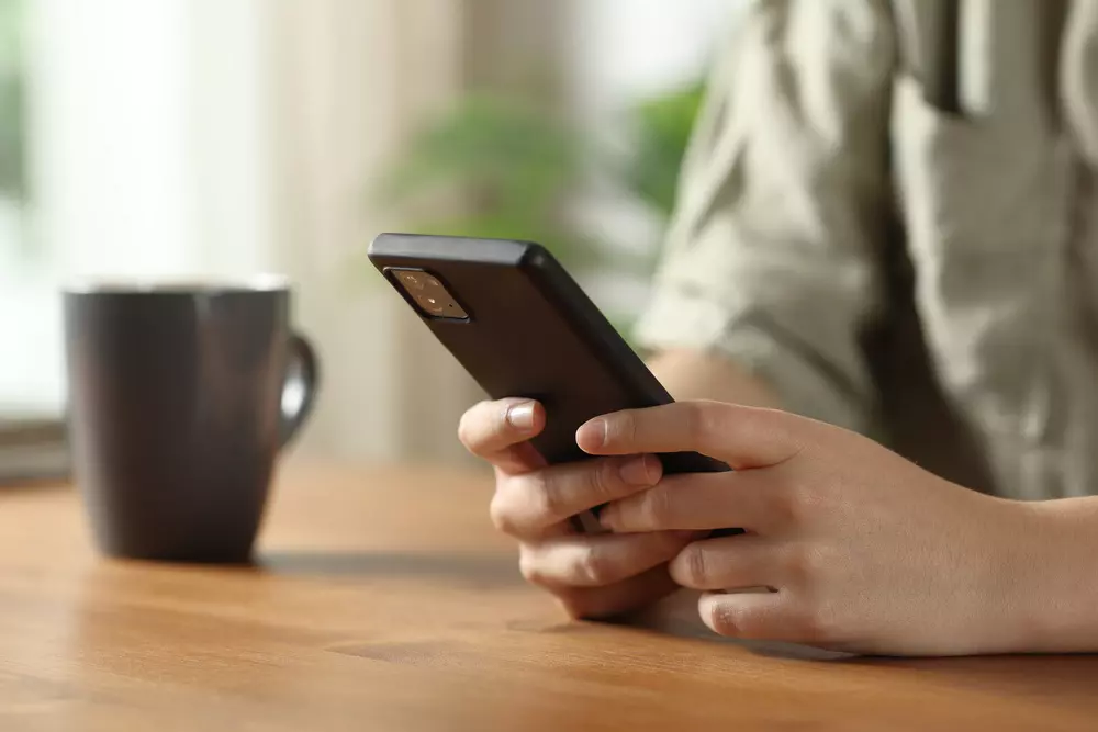 Pessoa segurando um smartphone na mão, destacando a importância dos minérios no dia a dia para tecnologia e eletrônicos.