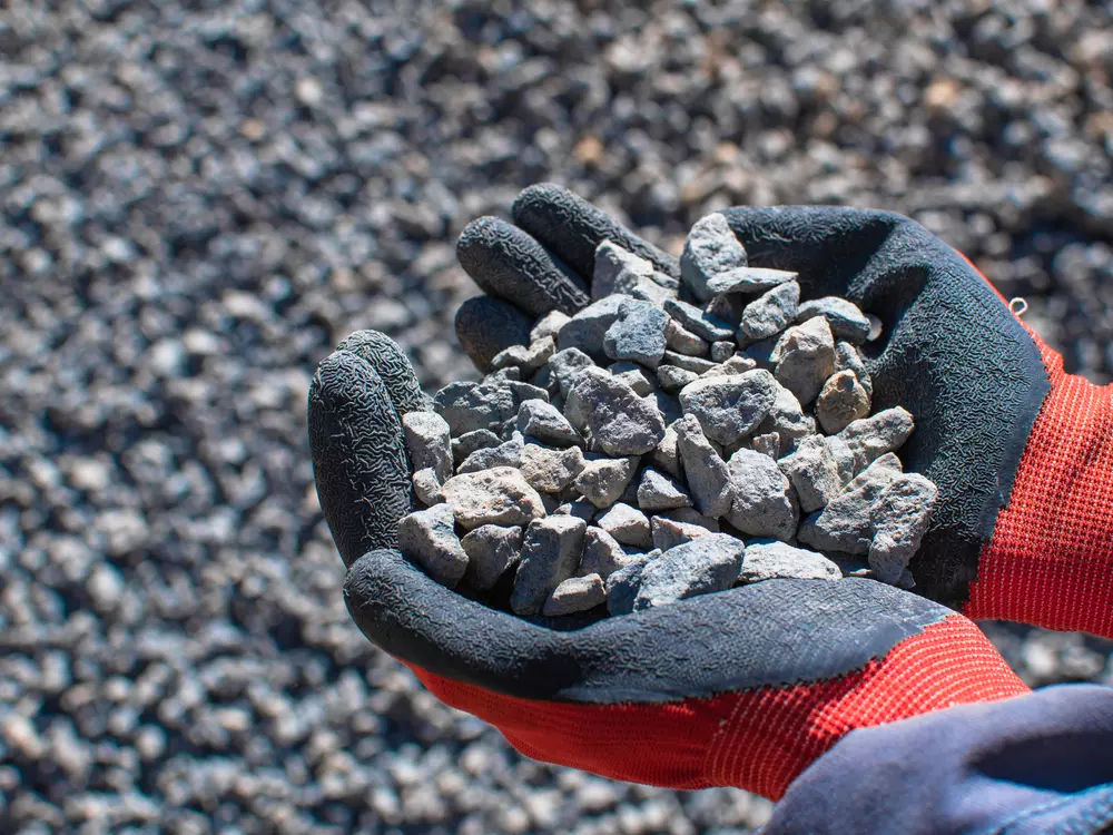 Pedras de terras raras nas mãos durante a mineração, destacando a importância dessas minerais raros e valiosos para tecnologia e indústria.