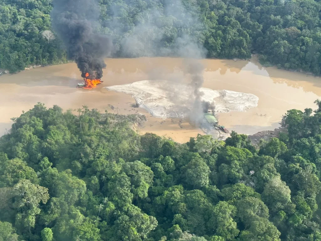 Balsa destruída durante a Operação Fronteira do Ouro na Amazônia, envolvendo Polícia Federal, com incêndio e destruição na água.
