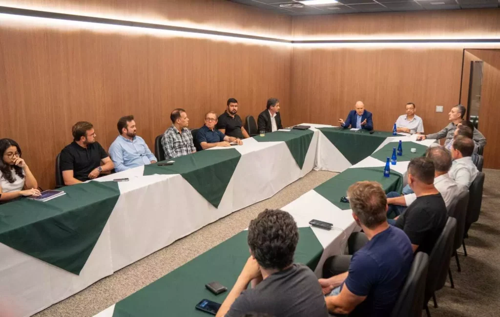 Reunião de representantes de mineradoras assinando carta de compromisso na cidade de Cuiabá, envolvendo discussões sobre mineração sustentável e regulamentações ambientais.