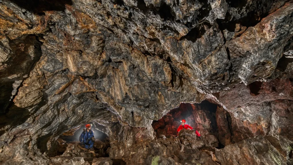 Exploração em cavernas com formações rochosas e cavidades, mostrando a complexidade das cavernas subterrâneas.
