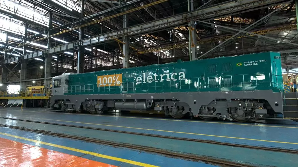 Locomotiva elétrica movida a baterias recarregáveis, com autonomia de 10 horas, promovendo a redução de emissões de carbono na estratégia de eletrificação ferroviária e de mineração.