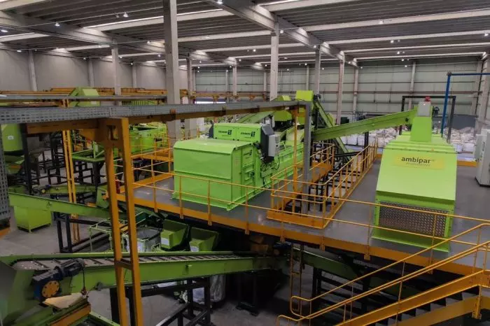 Maquinário industrial da Ambipar em operação, promovendo soluções sustentáveis de gerenciamento de resíduos na fábrica.