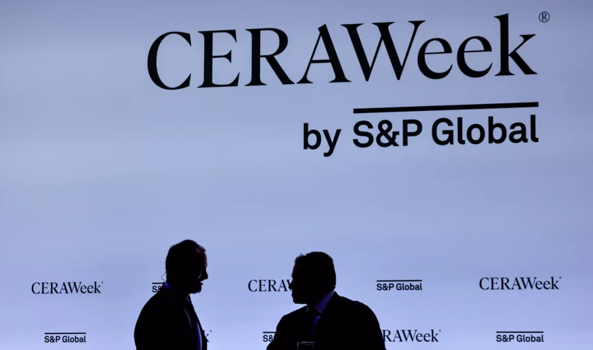 Painel CeraWeek com duas pessoas desfocadas