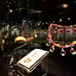 Exposição de joalheria em vitrine escura na Galeria William e Judith Bollinger, no Museu Victoria and Albert, Londres.
