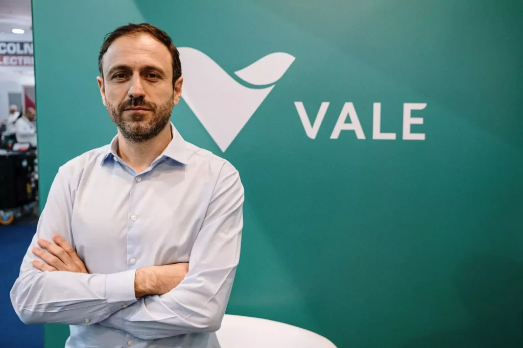 Rodrigo Bermelho, Diretor de Navegação da Vale, em evento corporativo, posando com braços cruzados ao lado do logo da Vale