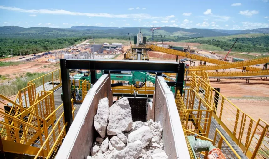Operação da Sigma Lithium no Vale do Jequitinhonha, Minas Gerais, destacando processos de mineração de lítio com máquinas pesadas em cenário natural