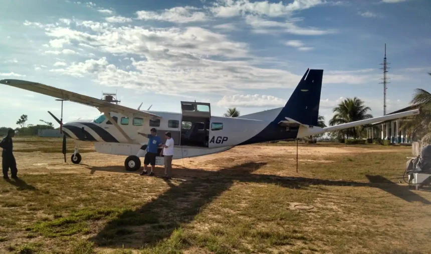 Aeronave em pista com equipe e técnicos em frente, enquanto a SGB prepara a retomada dos levantamentos aerogeofísicos no Brasil, com cenário tropical ao fundo.