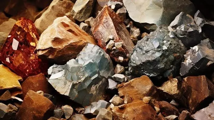 Pedras e minerais de terras raras, incluindo óxidos de cores vibrantes como vermelho, azul e cinza, utilizados na fabricação de componentes eletrônicos e magnetismo.