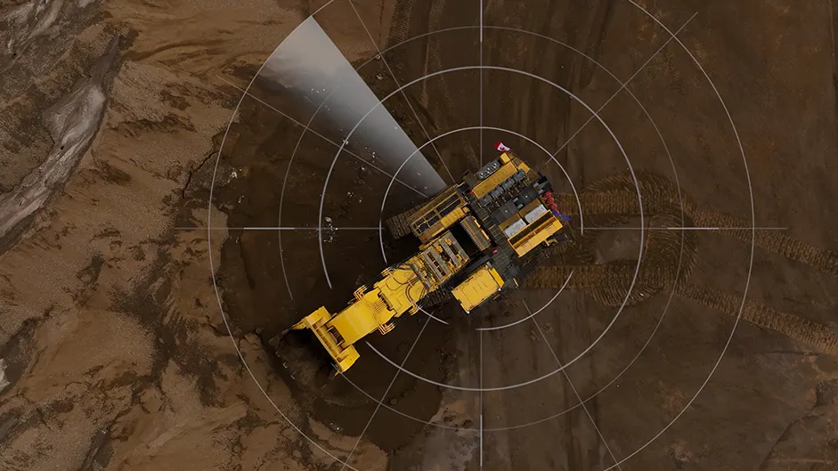 Uma escavadeira hidráulica da Komatsu em operação na mineração, com sobreposição de câmeras e círculos de visão para monitoramento e segurança da área de trabalho.