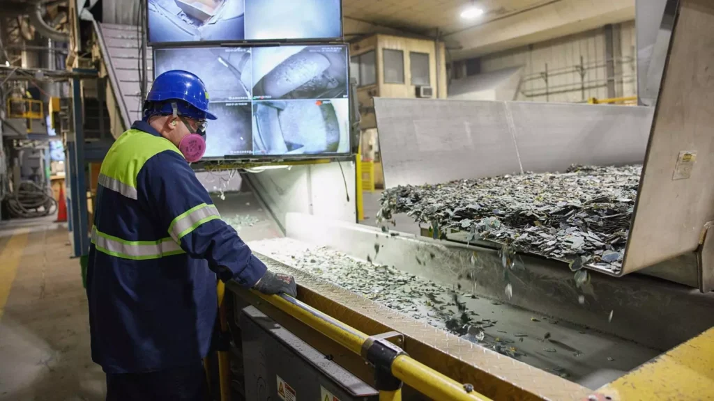Detalhe da esteira de triagem de materiais eletrônicos sob supervisão técnica e monitoramento por vídeo. A operação reflete o esforço do setor alinhado às novas ferramentas do ICMM para otimizar a circularidade de recursos.